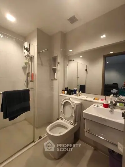 Modern bathroom with glass shower and sleek fixtures in a contemporary apartment.