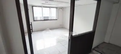 Bright empty room with large windows and tiled floor, ideal for office or study space.