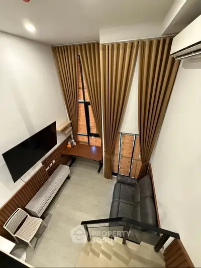 Modern loft-style living room with high ceilings and large windows