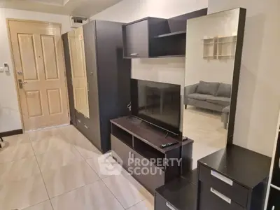 Modern living room with sleek furniture and wall-mounted TV in a cozy apartment.