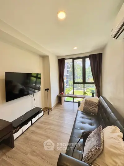 Modern living room with large TV and natural light from big windows