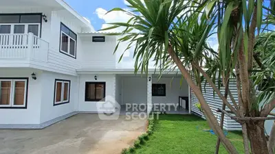 Stunning modern white house with lush green garden and spacious driveway.