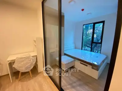 Modern bedroom with large window and study area in a stylish apartment