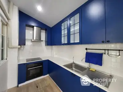 Modern kitchen with blue cabinets and sleek appliances in a stylish home