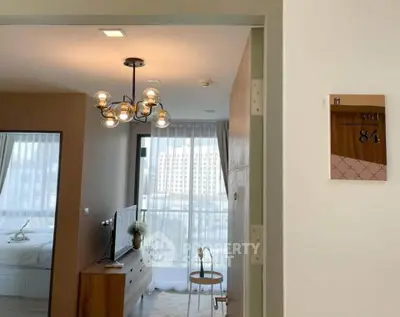 Modern apartment interior with stylish lighting and large windows offering city views.