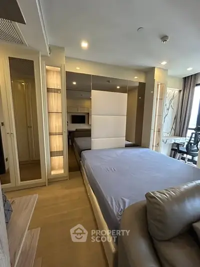 Modern bedroom with stylish decor and large windows offering natural light.