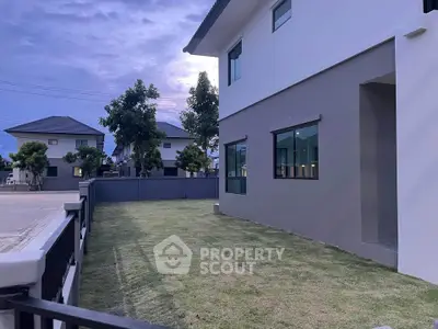 Modern suburban home with spacious lawn and contemporary design, perfect for family living.