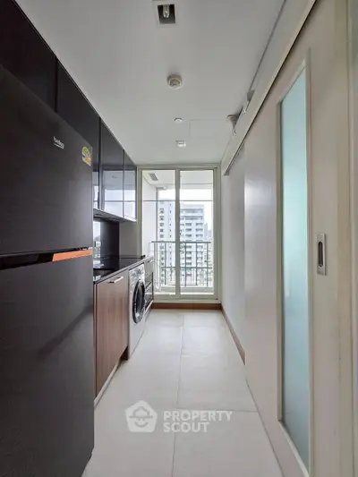 Modern kitchen with sleek appliances and city view balcony in high-rise apartment