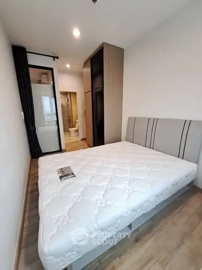 Modern bedroom with cozy bed and ensuite bathroom in a stylish apartment.