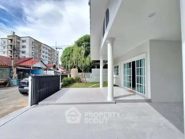 Modern building exterior with spacious driveway and elegant columns