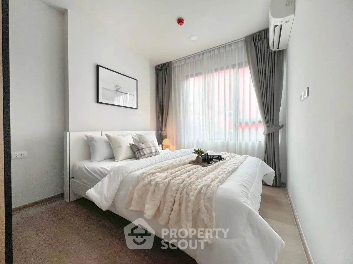 Modern bedroom with cozy decor and natural light, featuring a plush bed and elegant curtains.