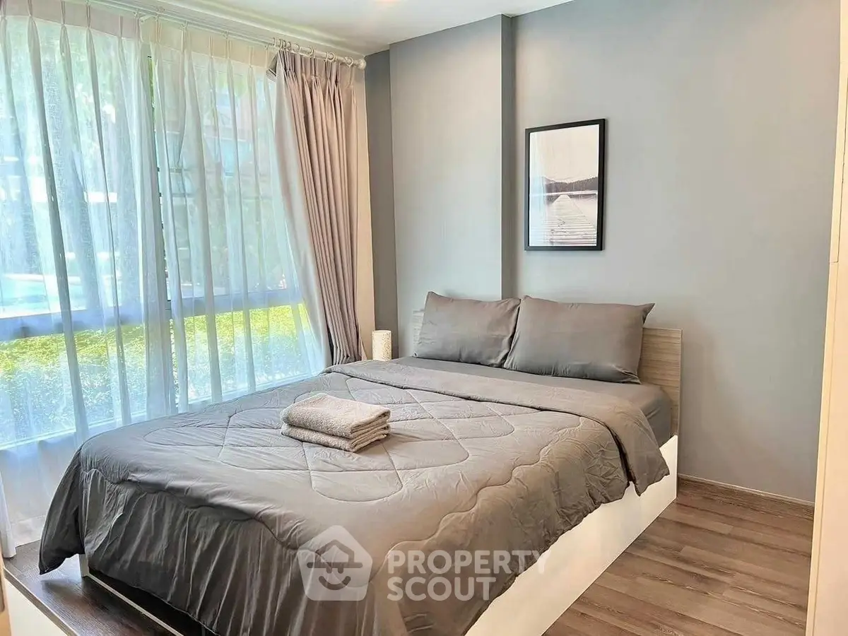 Cozy bedroom with large window and modern decor, perfect for relaxation and comfort.