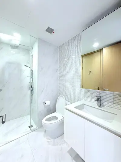 Modern bathroom with glass shower and sleek white fixtures