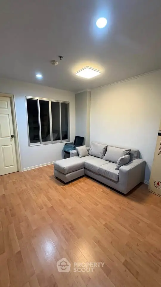 Cozy living room with modern sofa and wooden flooring, perfect for relaxation.