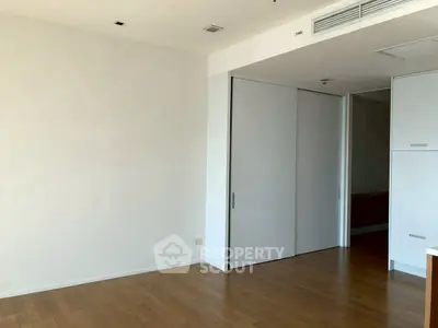 Spacious empty room with wooden flooring and sliding closet doors, perfect for customization.