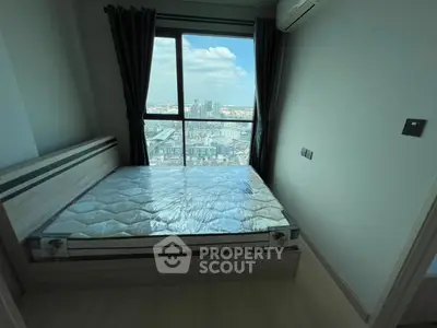 Modern bedroom with large window offering stunning city view, featuring a bed and air conditioning.