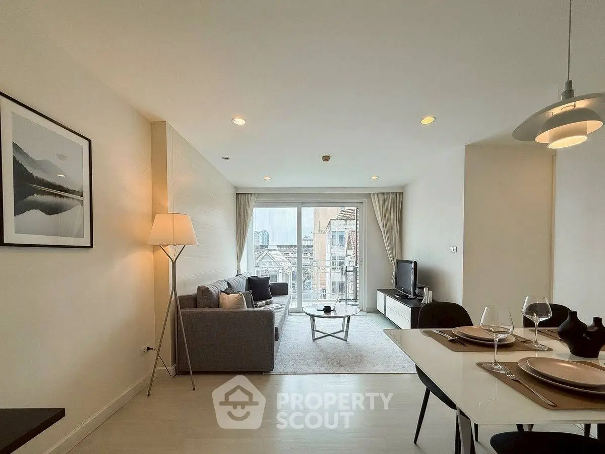 Modern living room with city view, stylish decor, and elegant dining area.