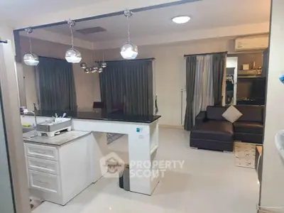Spacious open-plan living room with modern kitchen and stylish lighting fixtures.