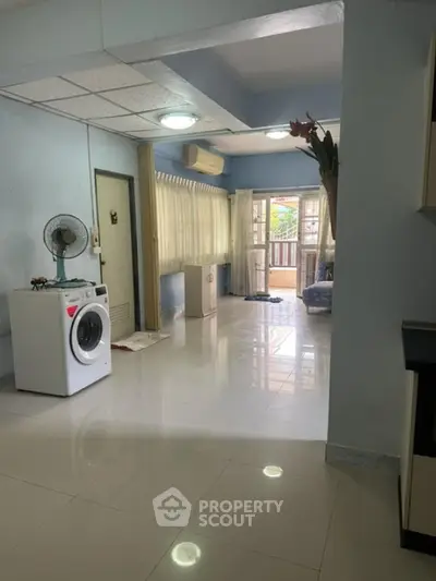 Spacious living area with washing machine and balcony access