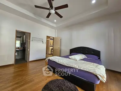 Spacious bedroom with modern ceiling fan and wooden flooring