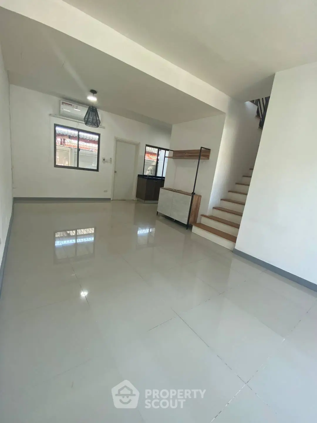 Spacious modern living room with sleek tiled flooring and staircase