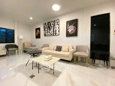 Modern living room with elegant decor and stylish furniture, featuring a cozy seating area and contemporary artwork.