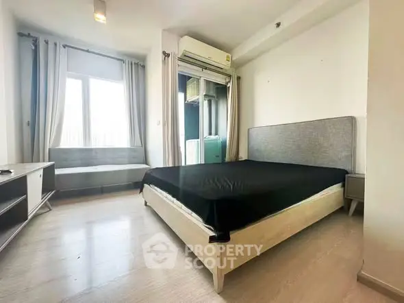 Spacious bedroom with modern furnishings and large window for natural light