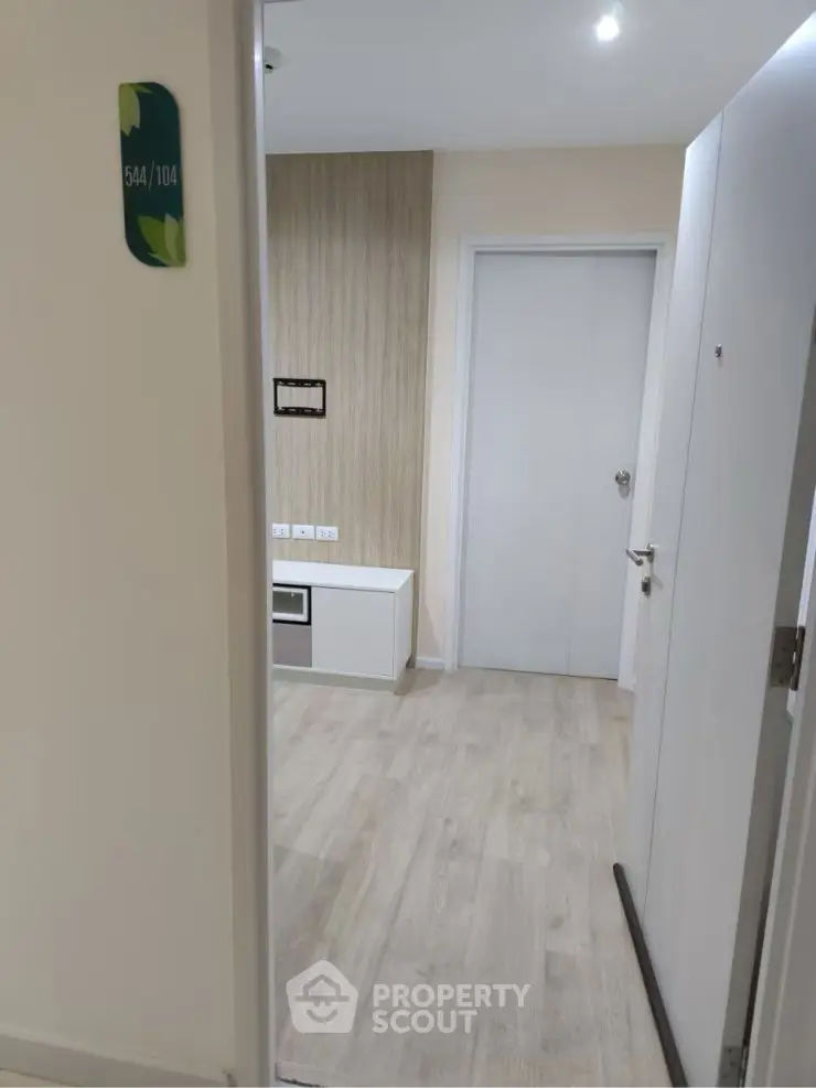Modern apartment entrance with sleek wooden flooring and minimalist design