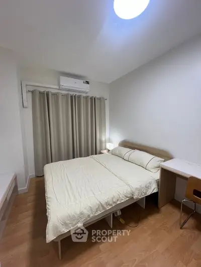 Cozy bedroom with modern furnishings and natural light, perfect for relaxation.