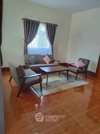 Cozy living room with elegant furniture and natural light, perfect for relaxation and gatherings.