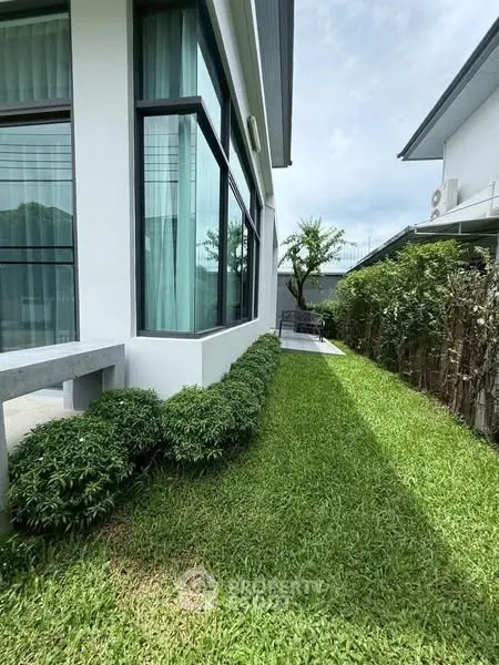 Modern house exterior with lush green garden and large windows