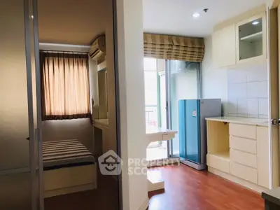 Cozy apartment interior with bedroom and compact kitchen featuring modern appliances.