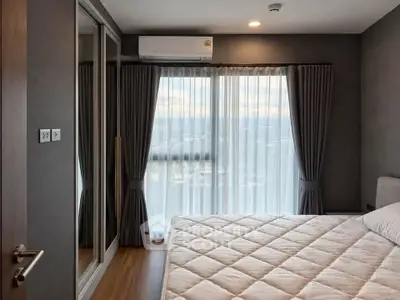Modern bedroom with large window and mirrored closet in stylish apartment