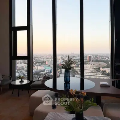 Luxurious high-rise living room with panoramic city view and elegant decor.