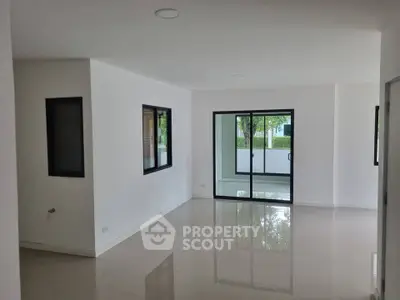 Spacious modern living room with large windows and glossy floors