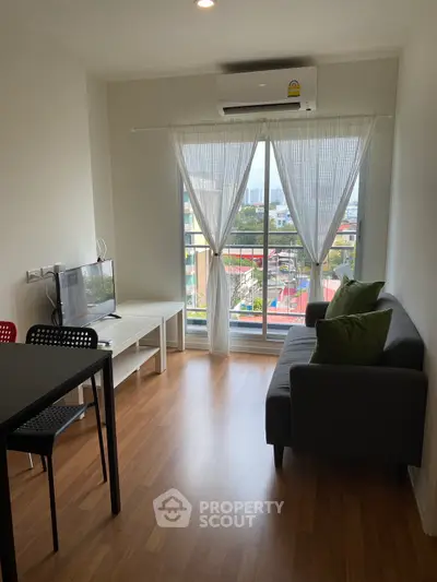 Modern living room with city view, featuring sleek furniture and natural light through large windows.