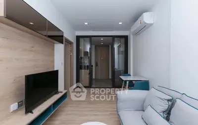 Modern living room with sleek design, featuring a cozy sofa, flat-screen TV, and air conditioning.