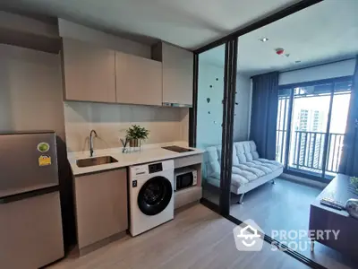 Modern condo kitchen with washing machine and cozy living area