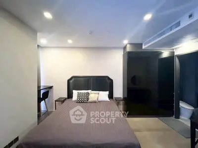 Modern bedroom with stylish decor and ensuite bathroom in luxury apartment.