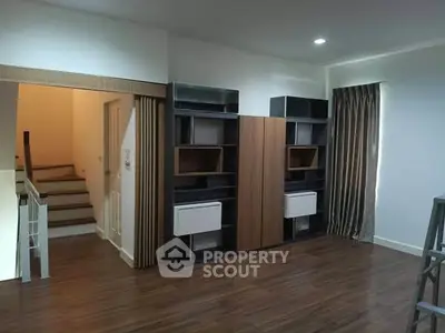 Spacious interior with modern wooden flooring and built-in shelving units.