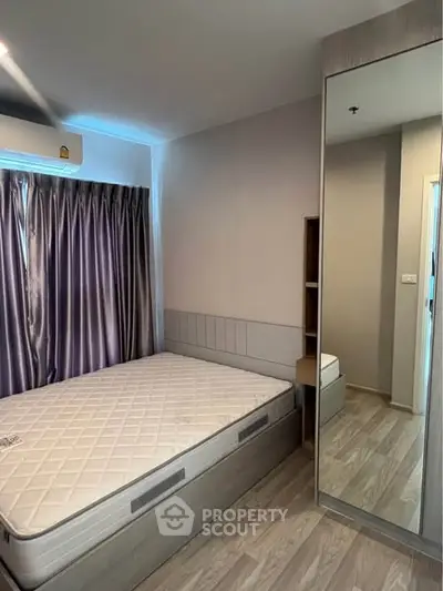 Modern bedroom with mirrored wardrobe and stylish curtains in a cozy apartment.