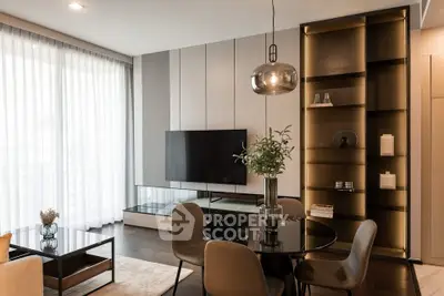 Modern living room with elegant decor, large TV, and stylish shelving