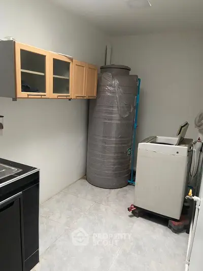 Utility room with washing machine and storage tank in modern home