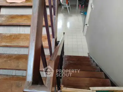 Wooden staircase leading to tiled floor in a residential interior setting.