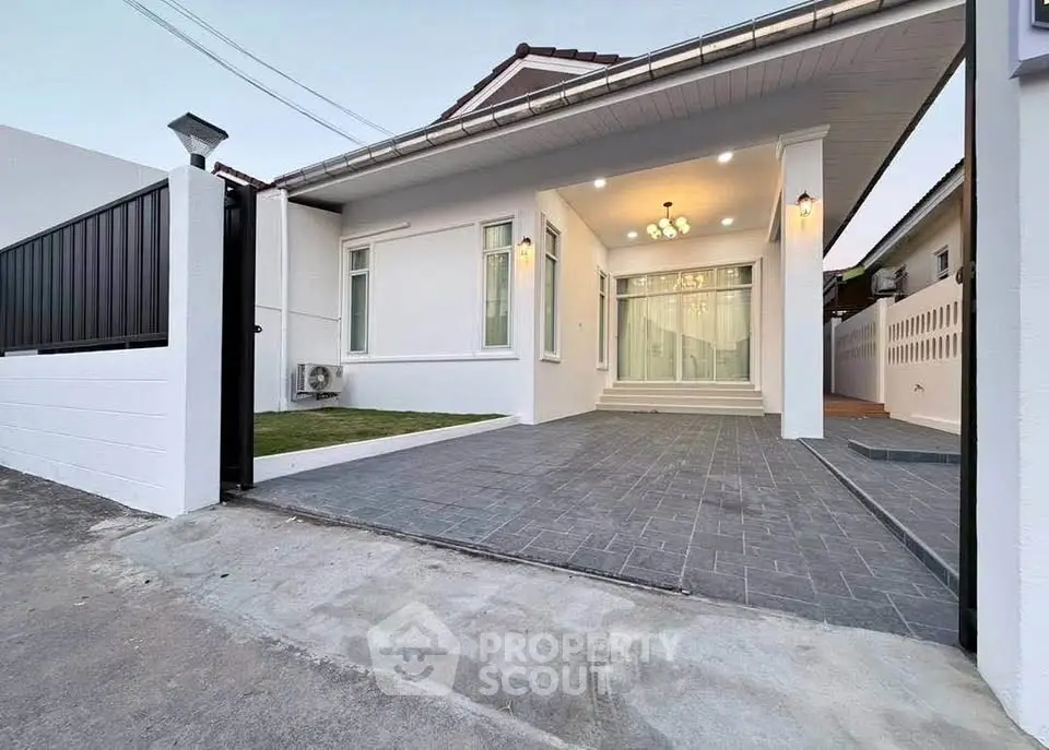 Modern single-story house with spacious driveway and elegant entrance lighting.