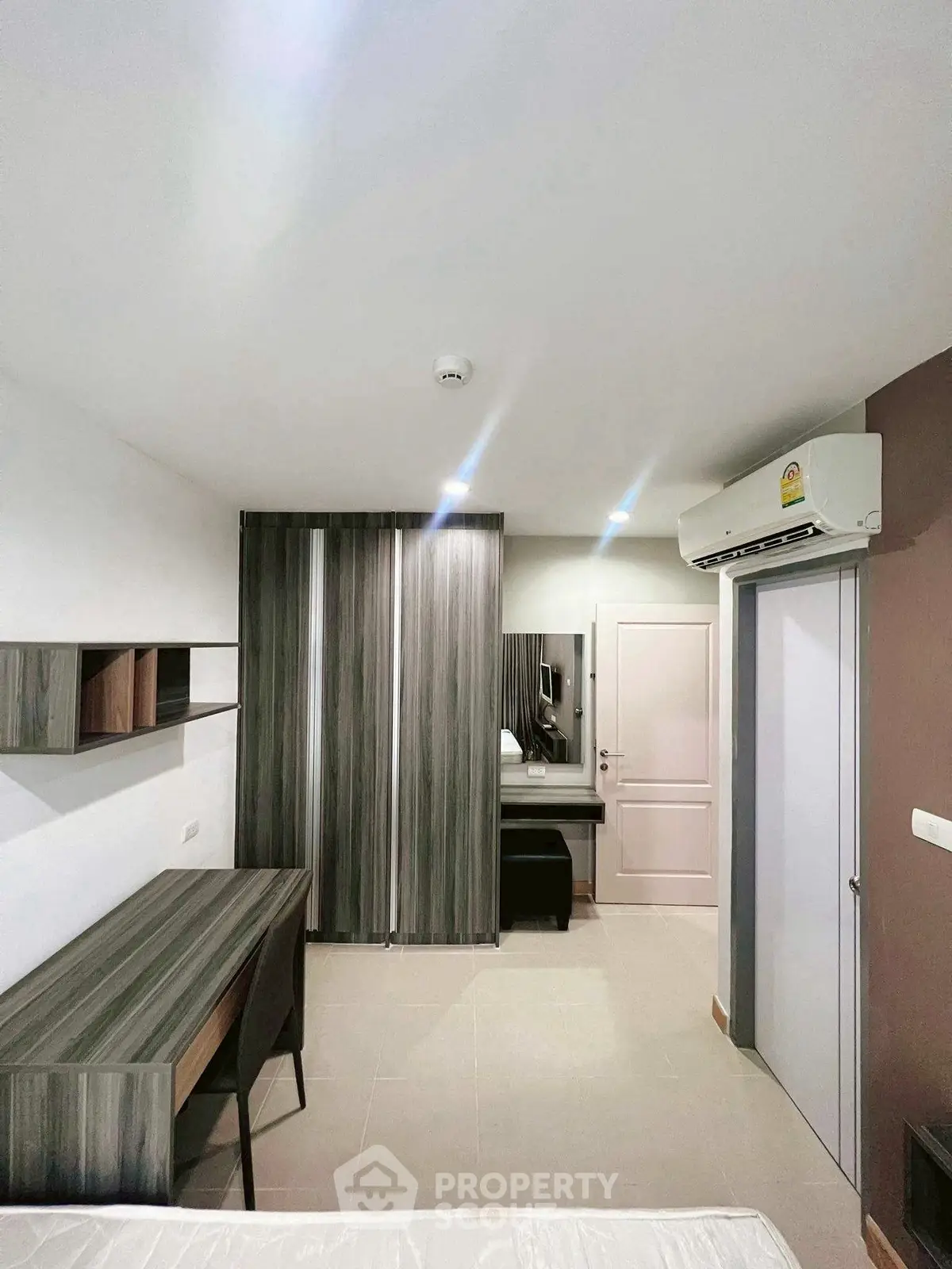 Modern bedroom with sleek furniture and air conditioning, ideal for comfortable living.