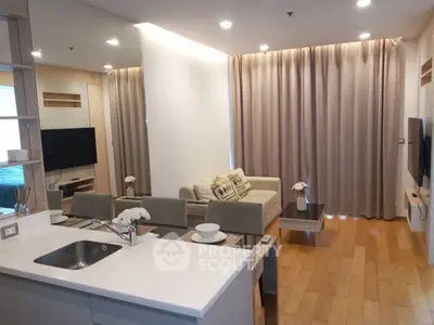 Modern living room with open kitchen, sleek design, and cozy ambiance in a stylish apartment.