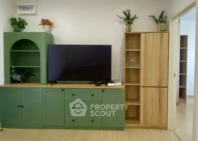 Modern living room with stylish green cabinetry and large flat-screen TV