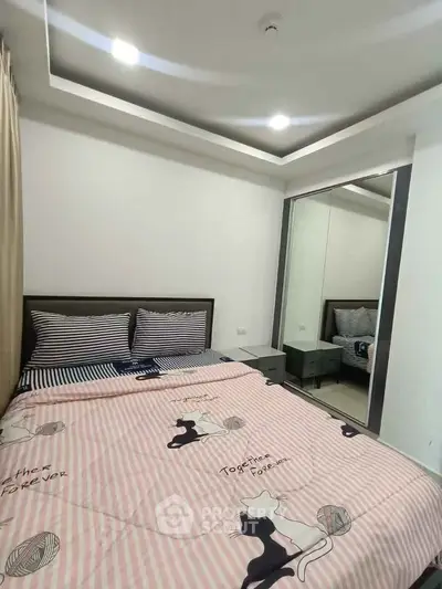 Cozy bedroom with stylish decor and mirrored wardrobe, perfect for modern living.