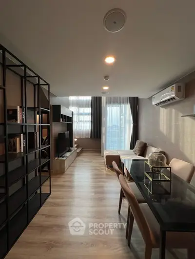 Modern living room with sleek furniture and large windows offering natural light.